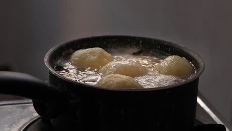 tortillas tradicionales de patata alemanas o kartoffelklöße hirviendo en una olla que muestra la vida cotidiana tranquila del hogar y la comida clásica de confort de invierno