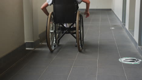 navigating independently, student in wheelchair moving down school hallway
