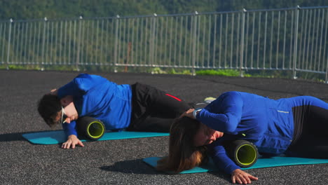 couple foam rolling outdoor exercise session