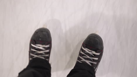 close view someone on black and red ice skates gliding on a smooth ice surface, capturing the essence of ice skating