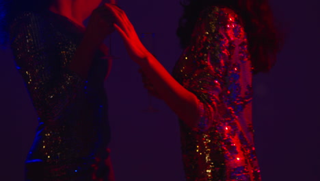 close up of two women in nightclub bar or disco dancing and drinking alcohol 6