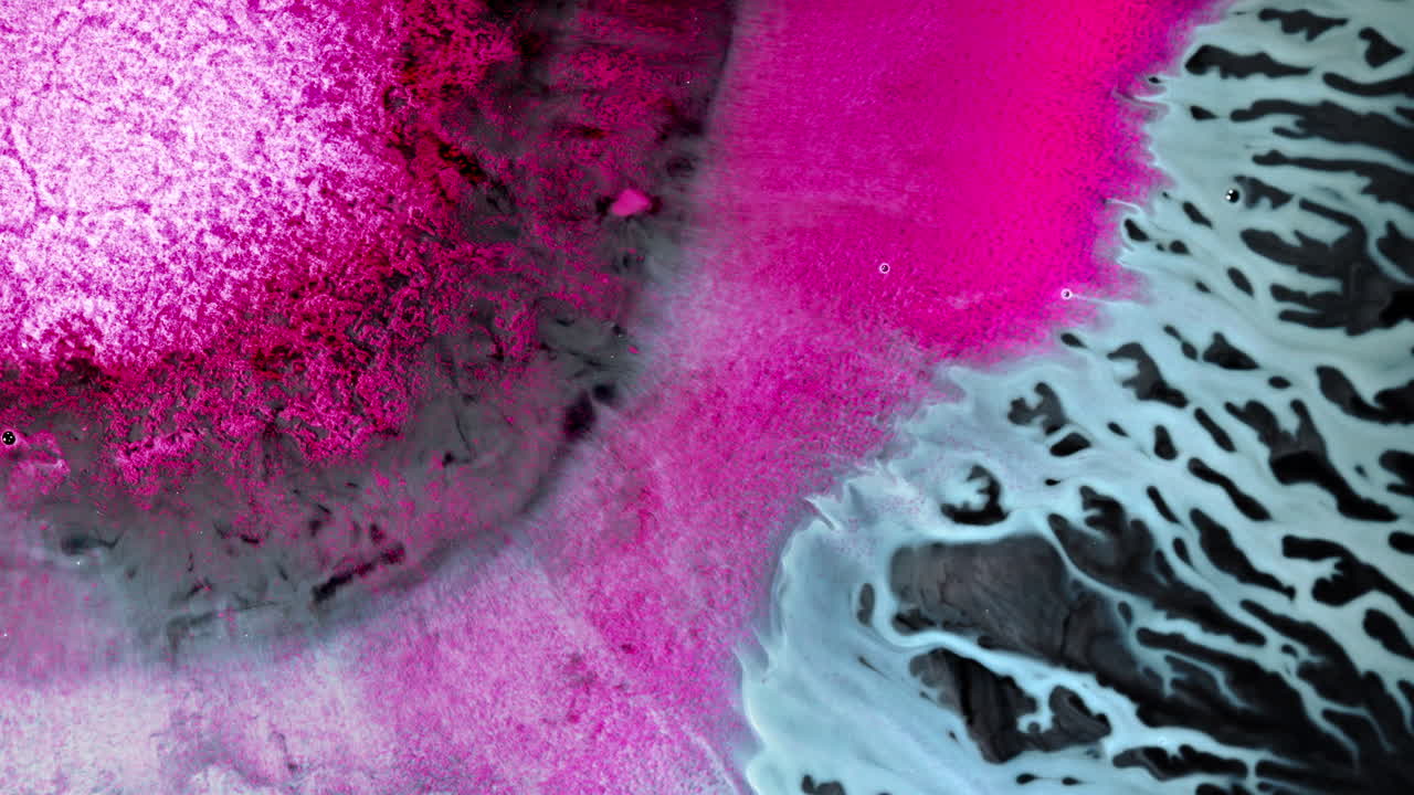 Abstract macro shot of swirling ink in vibrant pink and blue hues blending together