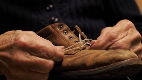 an intimate moment: craftsmanship in motion as hands skillfully tie laces on a classic brown shoe, showcasing the art of footwear care and attention to detail