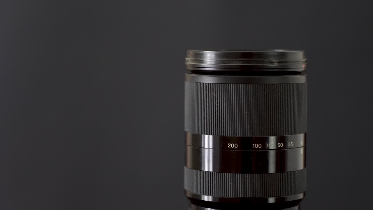 Black photo lens on a dark background