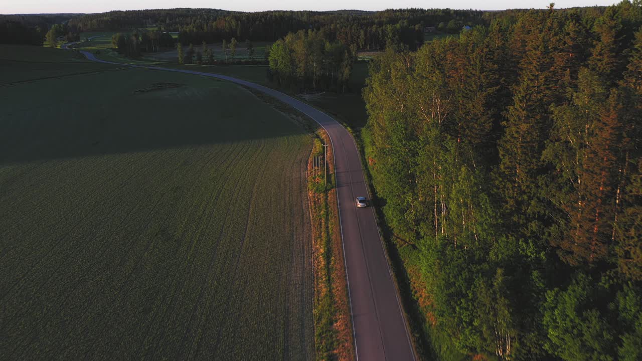 Car Travelling through Raasepori Countryside with Golden Autumn Colors, Drone video tracking view