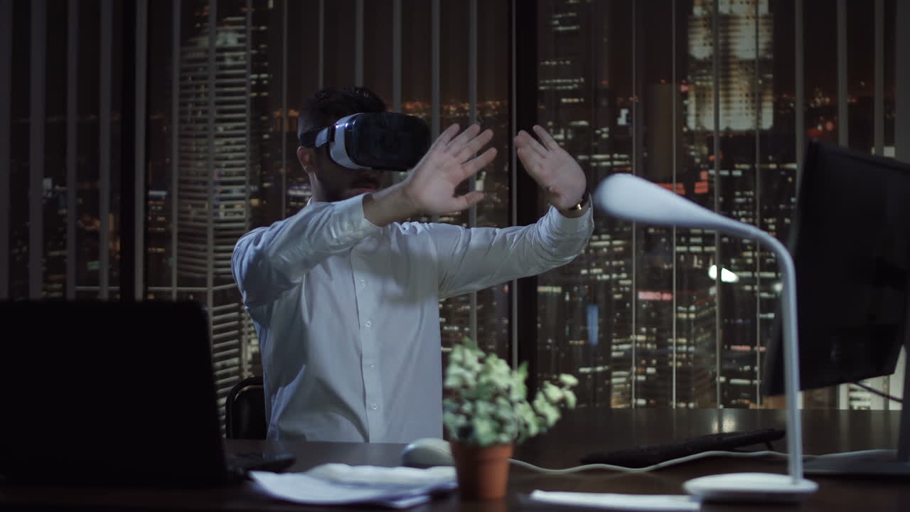 Man using VR headset in a modern office at night