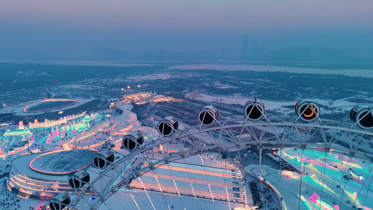 Slow aerial shot of snowflake Ferris wheel at sunset at Harbin Ice Festival with the city's skyline in the background, China