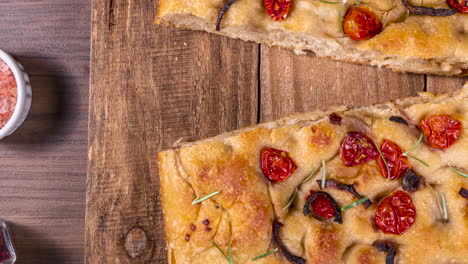 traditional italian focaccia with pepperoni, cherry tomatoes, black olives, rosemary ando onion - homemade flat bread focaccia