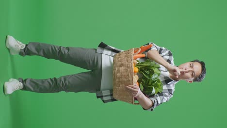 hombre sosteniendo una canasta de verduras y frutas