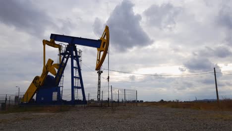 oil well pumpjack operating frantically, stormy sky time lapse, ploiesti romania