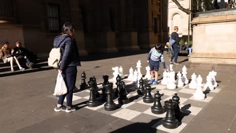 people playing giant chess outside library