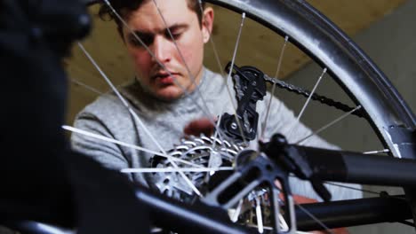 hombre discapacitado reparando una silla de ruedas en el taller 4k