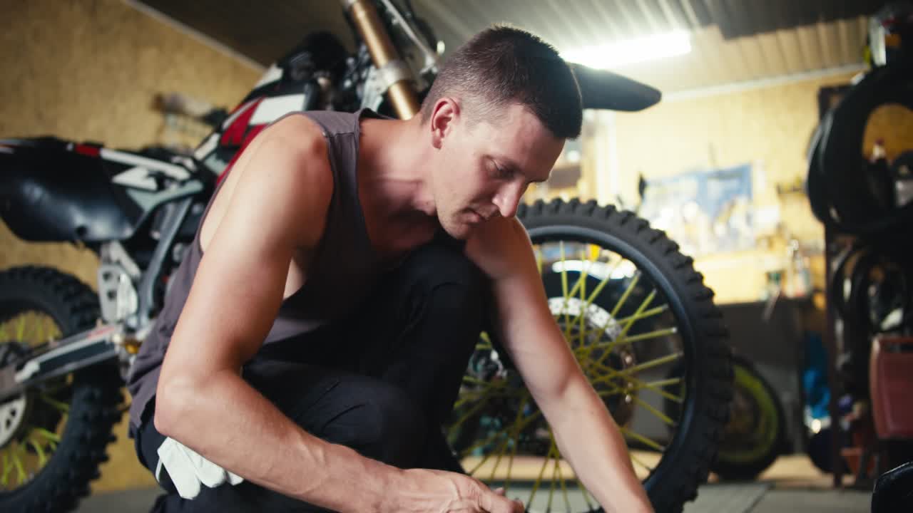 Close-up shot: a man with short hair in a gray T-shirt selects the necessary tools to begin repairing the bike