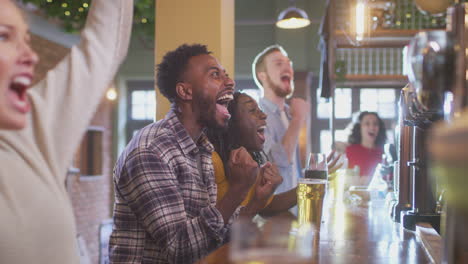 Grupo-De-Clientes-Emocionados-En-Un-Bar-Deportivo-Viendo-Eventos-Deportivos-En-Televisión