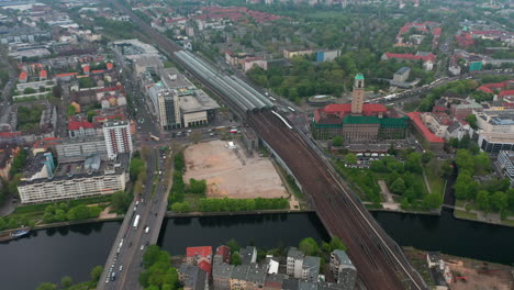 Slide-and-pan-footage-of-Spandau-train-station-with-long-train-sheds-on-multitrack-railway-line.-High-angle-view-of-town.-Berlin,-Germany