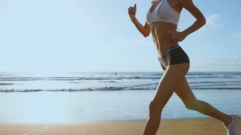 Beautiful-sporty-women-in-white-sneakers-running-along-a-beautiful-sandy-beach,-healthy-lifestyle.-Rear-view.-SLOW-MOTION-STEADICAM.