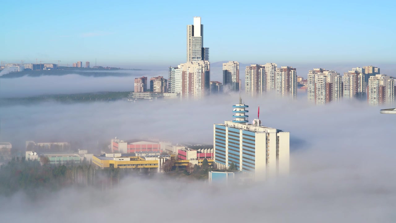 Grattacieli moderni della città che si ergono sopra una fitta nebbia mattutina