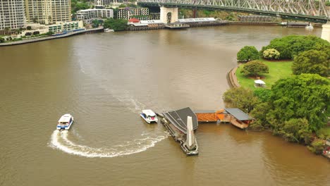 ferry leaving terminal, brisbane river after floods, story bridge, brown water