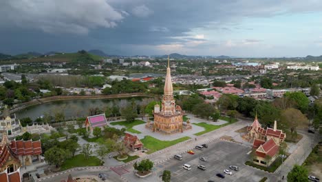 wat chalong stands prominently in phuket, thailand, surrounded by greenery and cityscape under dramatic skies