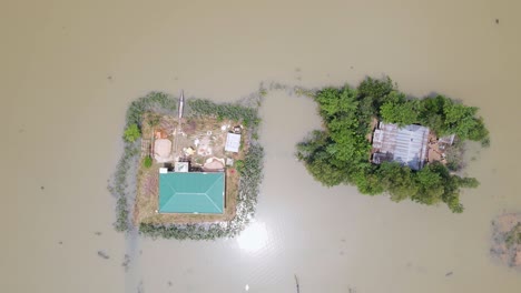 rural houses submerged in flood water in bangladesh. aerial top down view