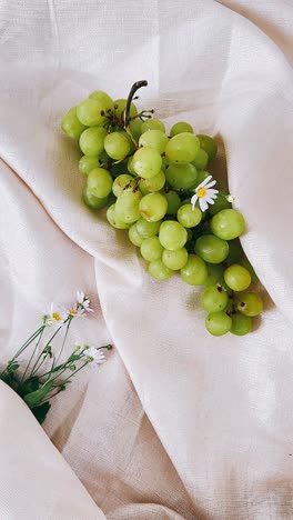 green grapes and daisies on linen