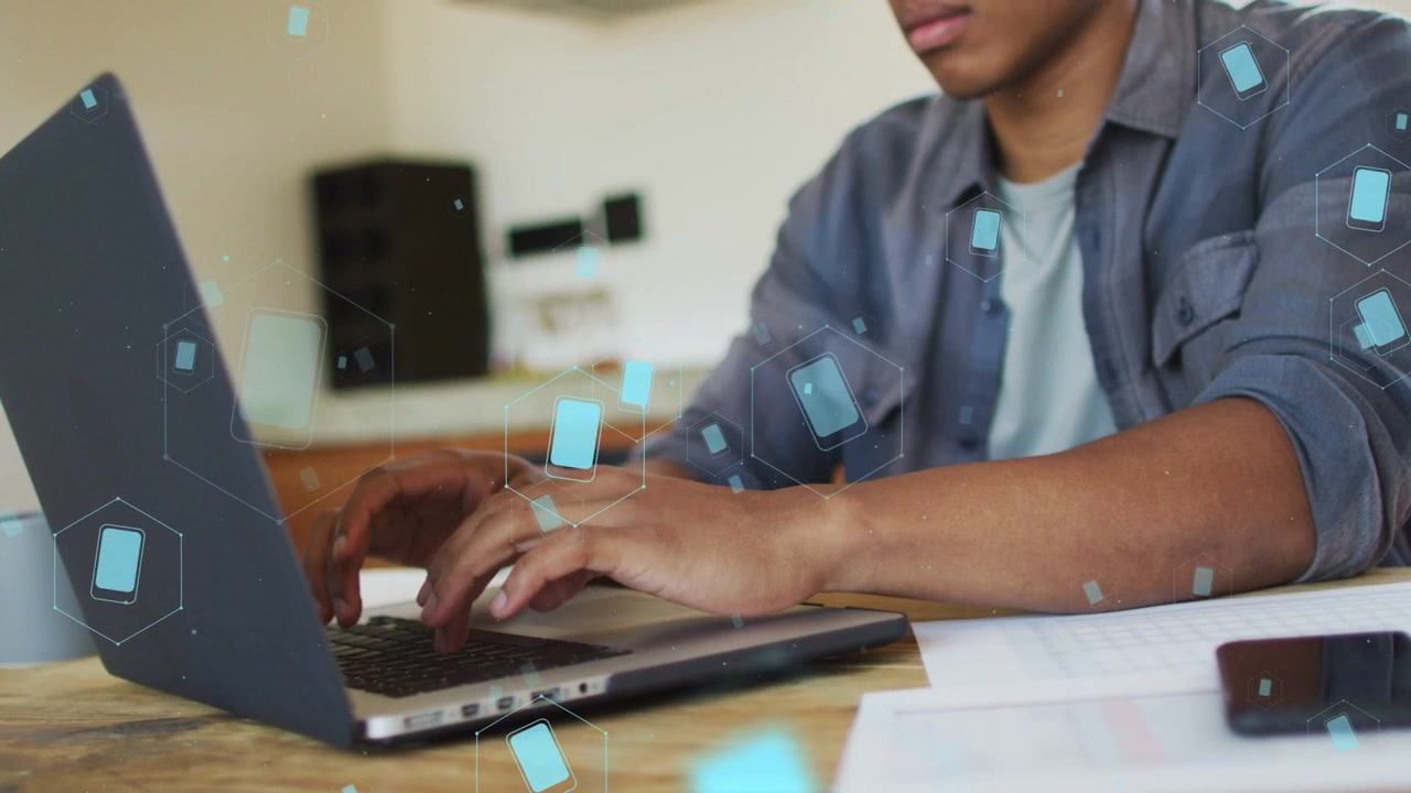 Profissional de tecnologia olhando papéis e digitando no laptop, trabalhando, com sobreposições de UI azuis destacando as teclas.