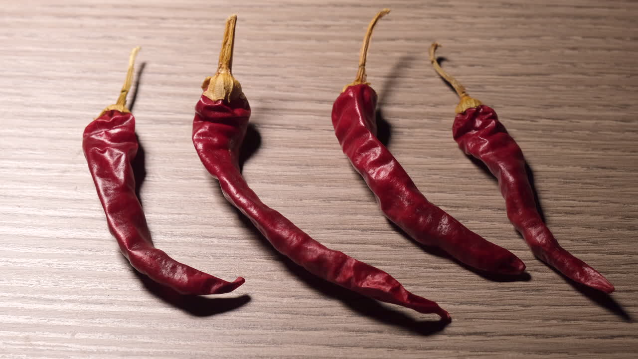 Chili peppers illuminated on wooden background
