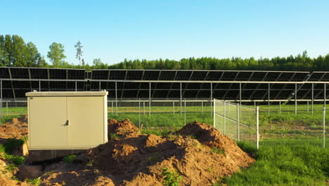 paneles solares en un sitio de energía renovable en construcción con césped y caja de servicios públicos