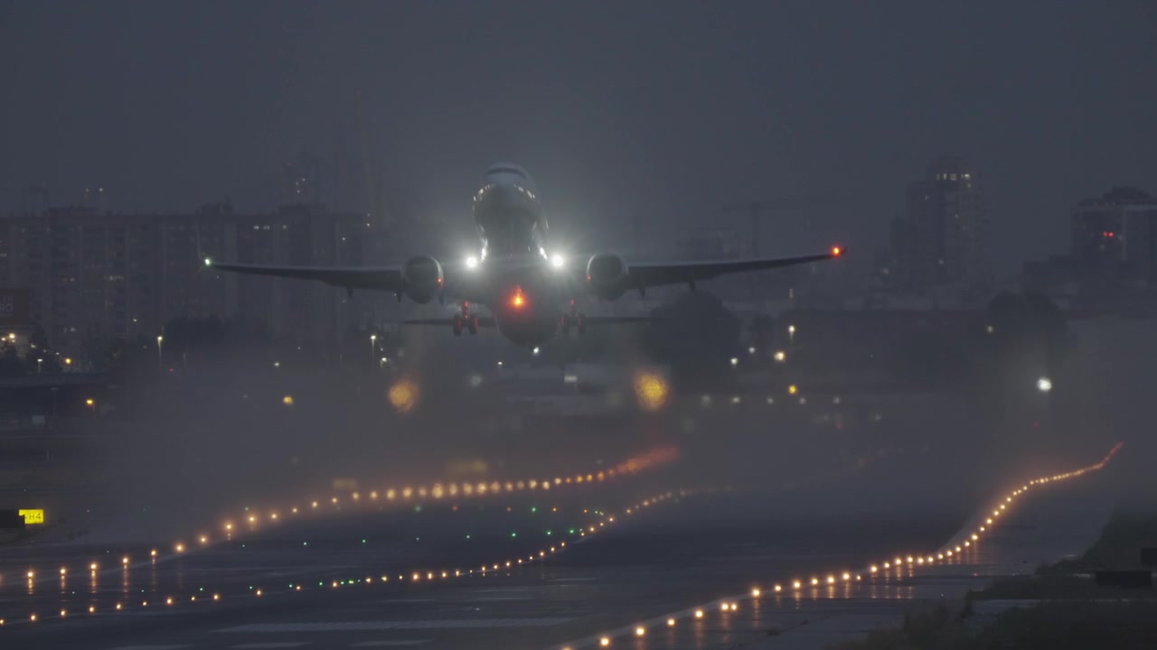 Aereo decolla da pista bagnata di notte