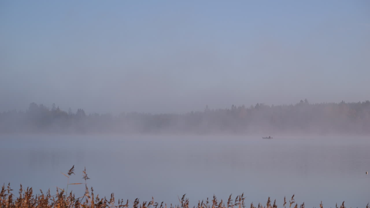 안개와 평화로운 아침에 군도 근처에서 항해하는 외로운 보트