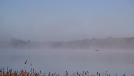 lone boat sailing near archipelago on foggy and peaceful morning