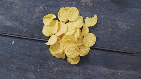 close up view of potato chips falling with copy space on wooden surface