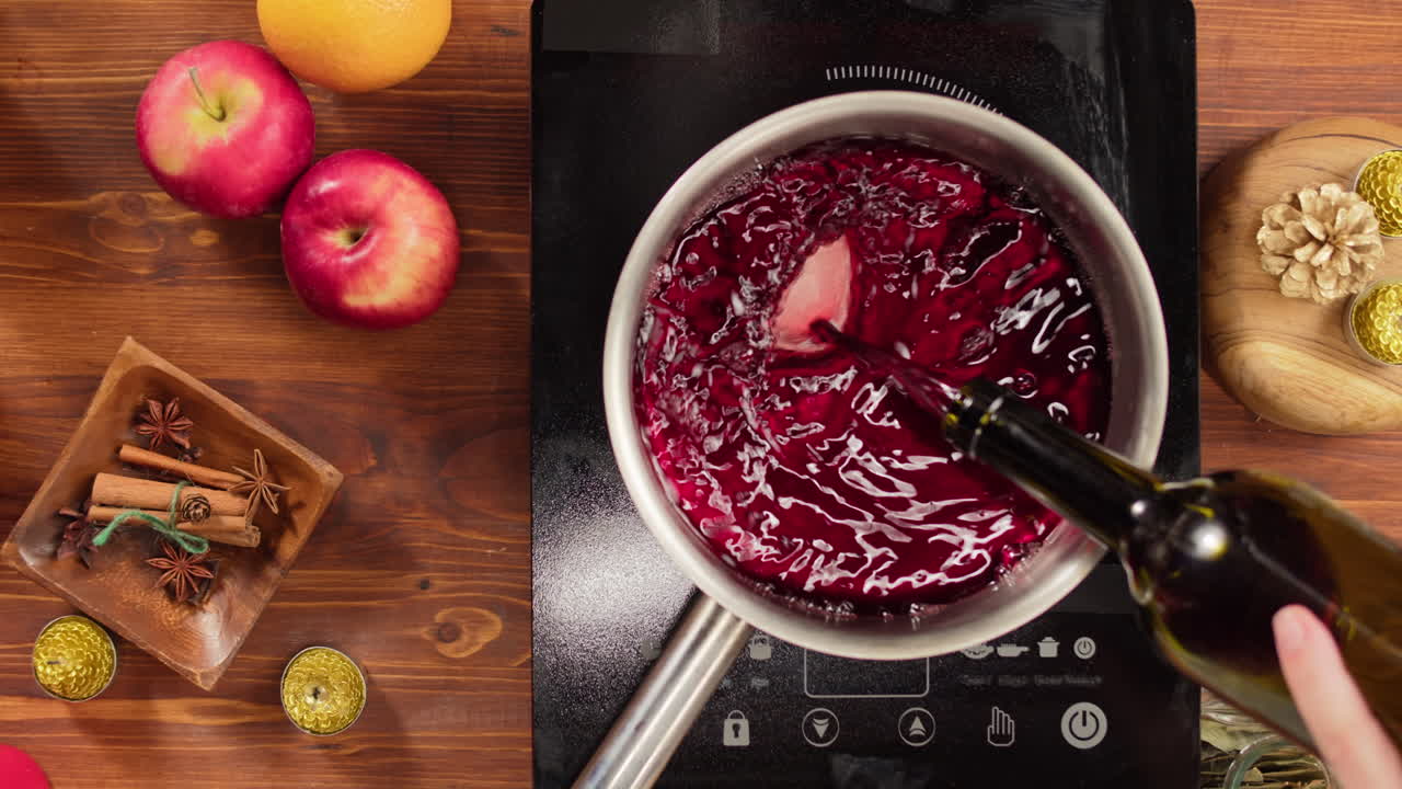 Versamento di vino rosso in una casseruola per la preparazione del Vin Brulé