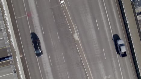 Aerial-top-down-of-multi-level-highway-road-with-traffic-driving-in-all-directions,-drone-zoom-out-revealing-urban-crossroad-with-car-and-truck