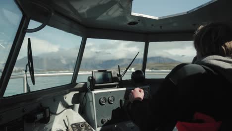 man steering boat through icebergs in iceland