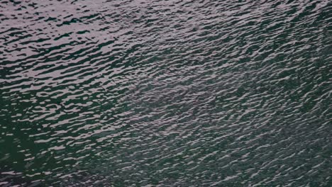 The-water-at-Durdle-Door,-Lulworth,-Dorset,-UK-moving-in-little-waves