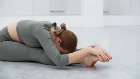 woman practicing seated forward bend yoga pose