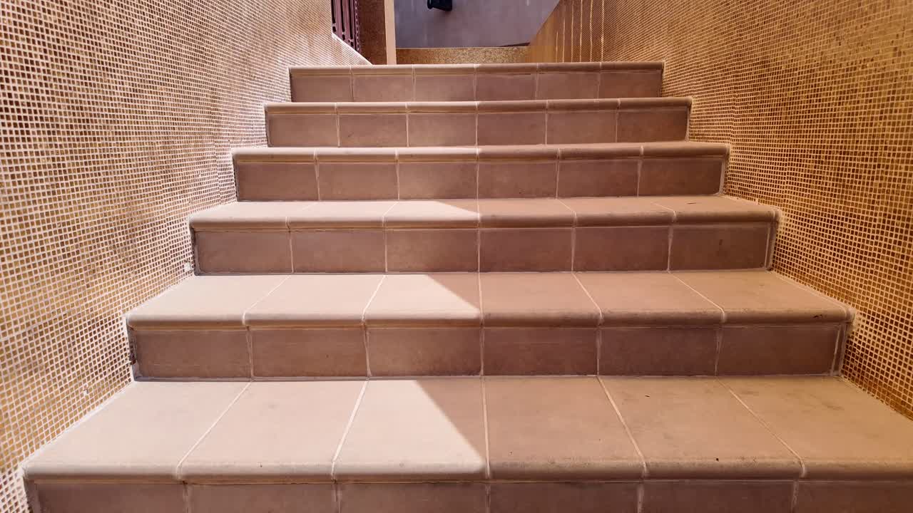 황금 모자이크 벽과 함께 갈색 타일 내부 계단