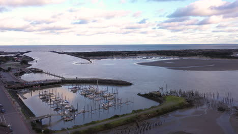 vista aérea del casco antiguo de bandon y puerto deportivo con horizonte sobre el océano, órbita de drones