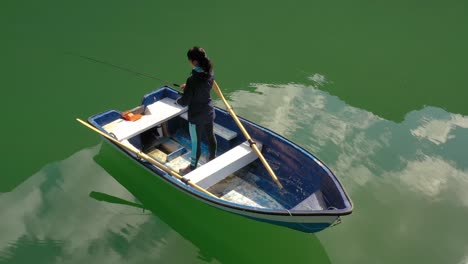 Woman-on-the-boat-catches-a-fish-on-spinning-in-Norway.