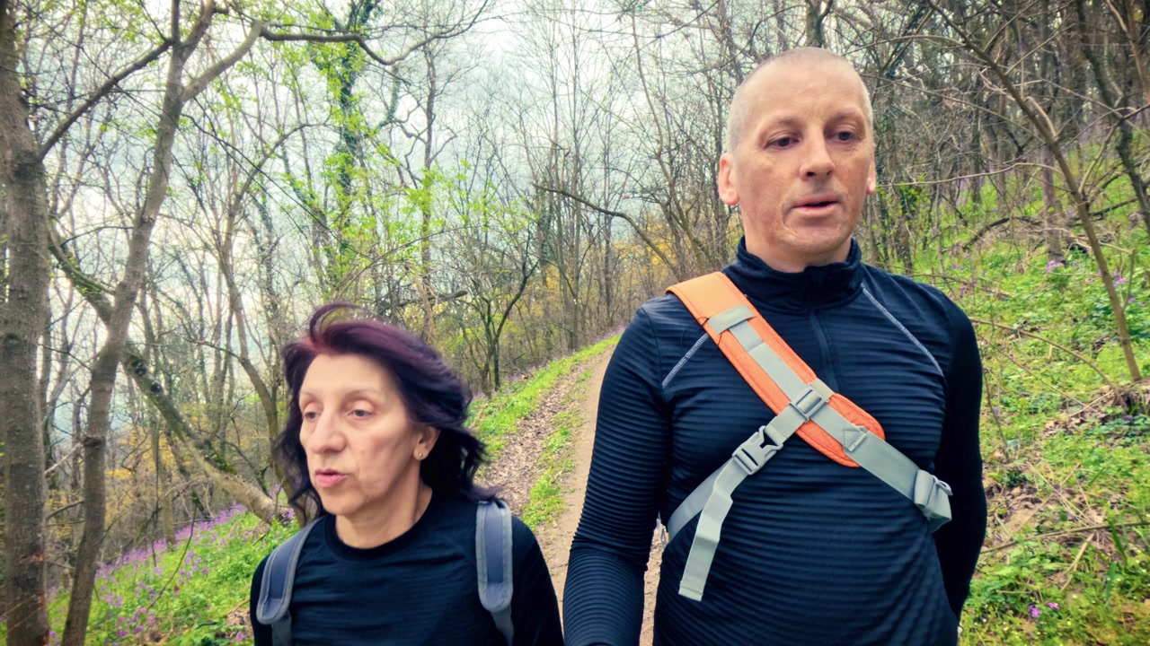 Authentic couple performing light physical activity in nature. Concept of cardiovascular health, hypertension prevention, and healthy lifestyle for middle aged people.