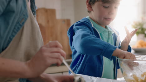 little boy helping mother bake in kitchen putting cookie dough onto tray preparing homemade recipe at home with mom teaching her son on weekend