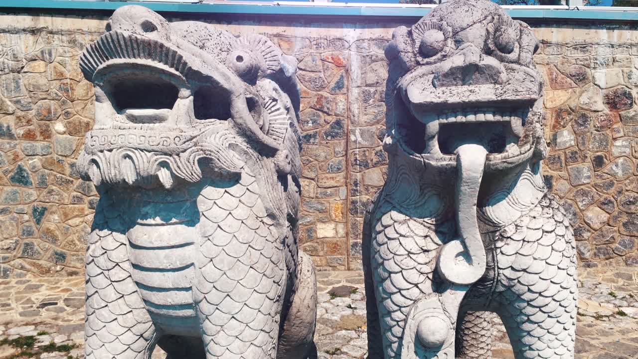 león de piedra en la orilla