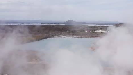 volando a través del vapor de la planta de energía geotérmica bjarnarflag con lago azul