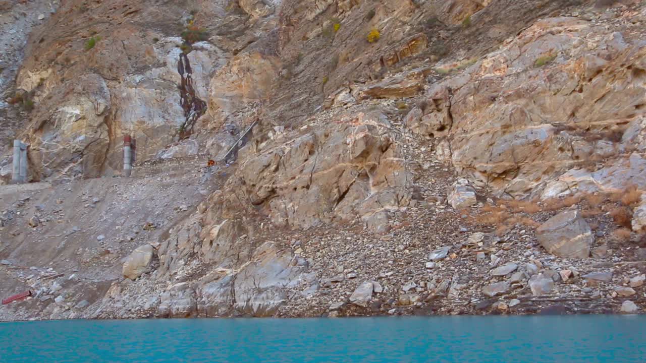 Macchinari pesanti che costruiscono il ponte tra le montagne. Ripresa delle montagne sopra il lago con una nave.