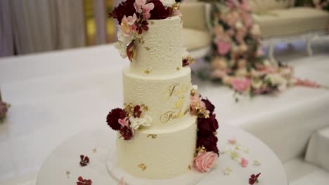 a lovely close-up shot capturing the beautiful decoration of a wedding cake in the venue hall.
