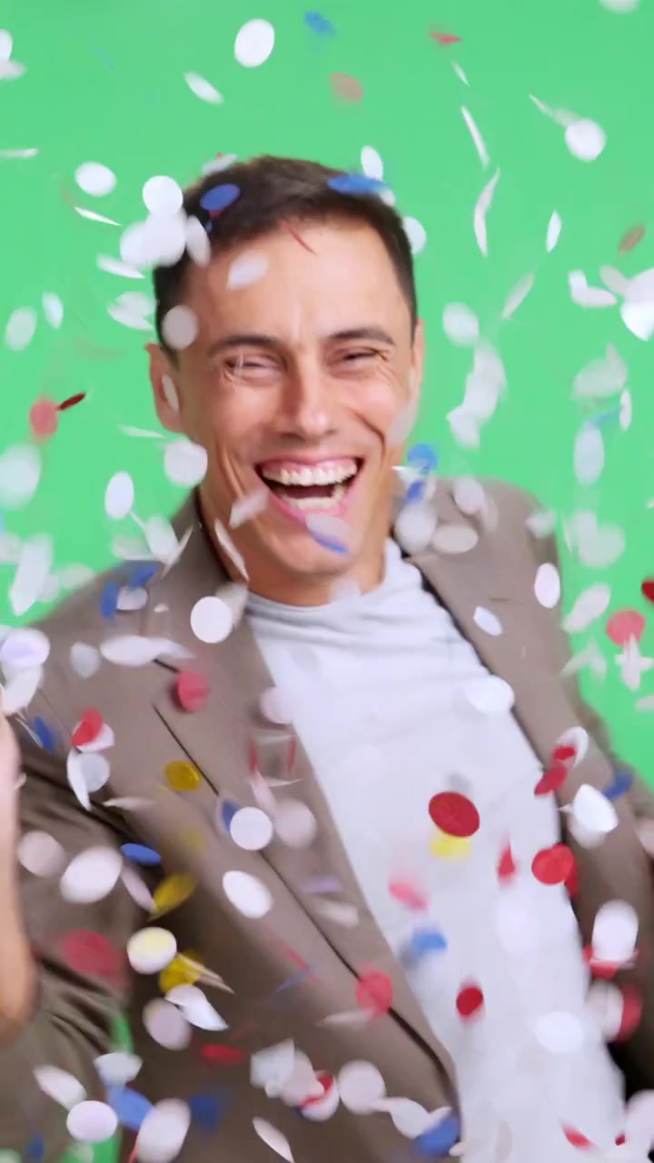 Uomo felice che balla sotto una pioggia di coriandoli per festeggiare