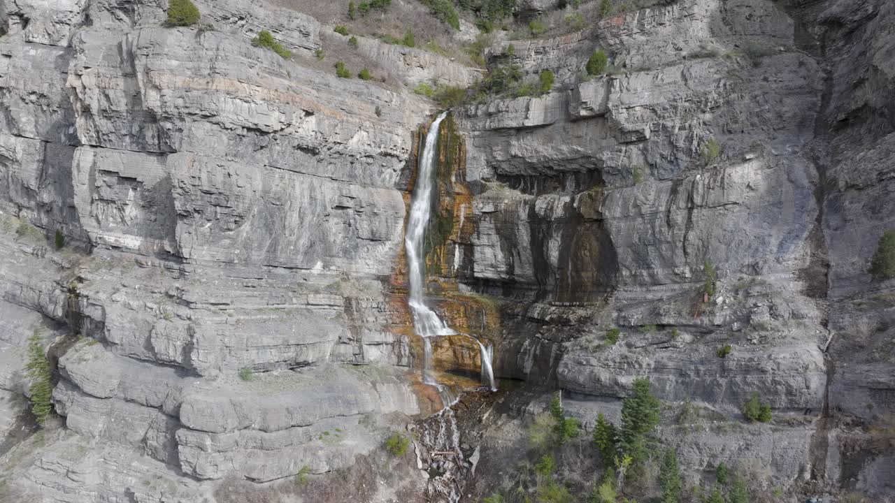 empuje aéreo y panorámica de las montañas más allá del velo de la novia cae en american fork canyon, utah durante la primavera