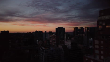 drone stands in one place over the city at sunset, blue-pink sky, cold