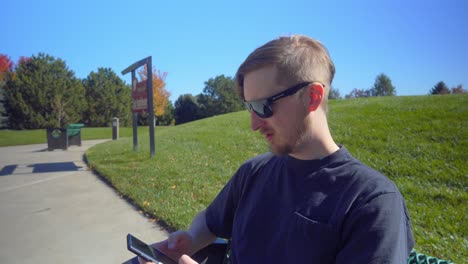 a man sits on a park bench to make a phone call